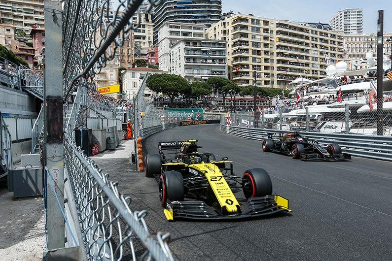 formula one racing in monaco, going past luxury yachts